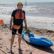 Alistair McKenna on Sidmouth town beach with his kayak