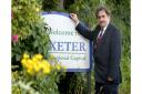 Pete Edwards at a 'Welcome to Exeter' sign.
