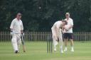 Freddie Fenner bowling for Whimple whilst Mark Burnard looks on