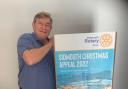 Mike Goodman of Sidmouth Rotary with a board advertising their appeal