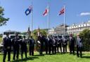 Falklands veterans gather under the British and Falkland Islands flags on the Triangle