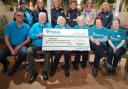 Hospiscare volunteers and Otter team members with the Hospiscare conation cheque