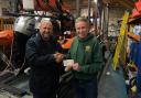 Tim Clay, treasurer of Sidmouth Running Club, presents the cheque to Sidmouth Lifeboat's senior tractor driver Paul May.