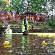 Student helpers keep the ducks moving in the race