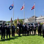 Falklands veterans gather under the British and Falkland Islands flags on the Triangle