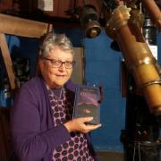 Janet Dowling at Norman Lockyer Observatory with a copy of her book